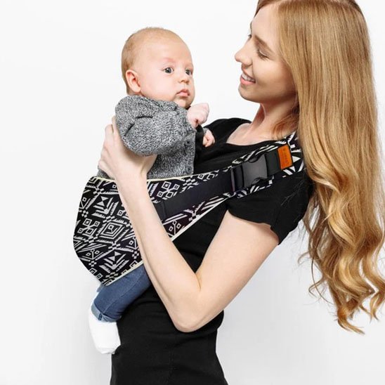 maman joue avec bébé dans écharpe de portage bébé