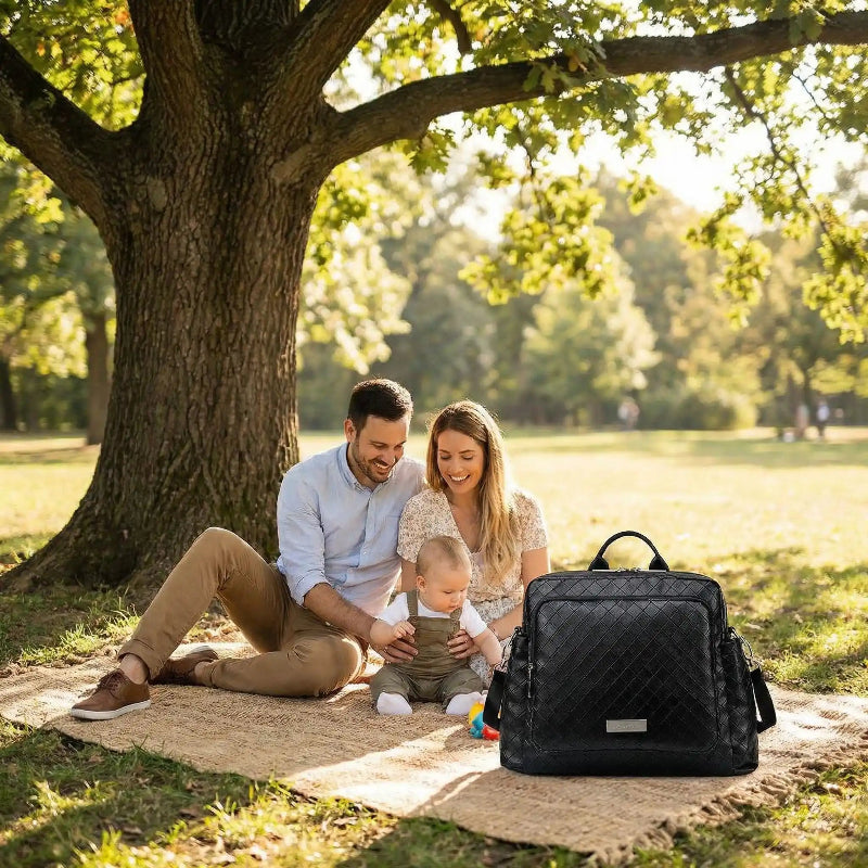 sac à langer maman et papa assis sous arbre avec bébé
