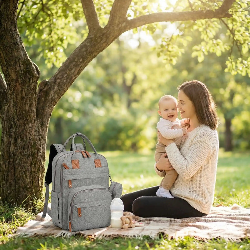 sac à dos à langer bébé nomade maman et enfant sous un arbre