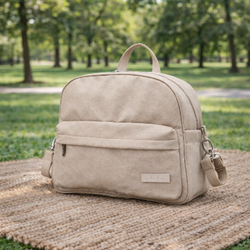 sac a langer a dos serenite beige sur le sol avec un tapis