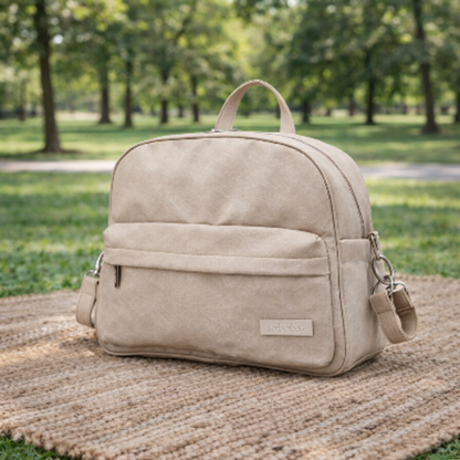 sac a langer a dos serenite beige sur le sol avec un tapis