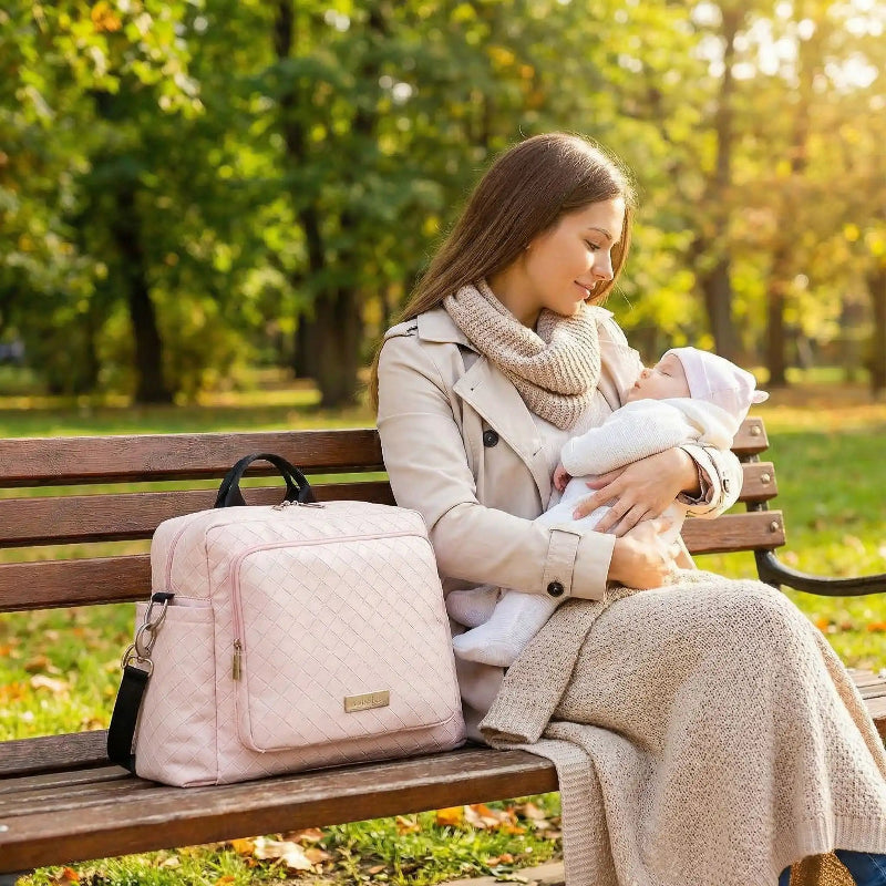 sac à langer maman assise avec bébé sur banc
