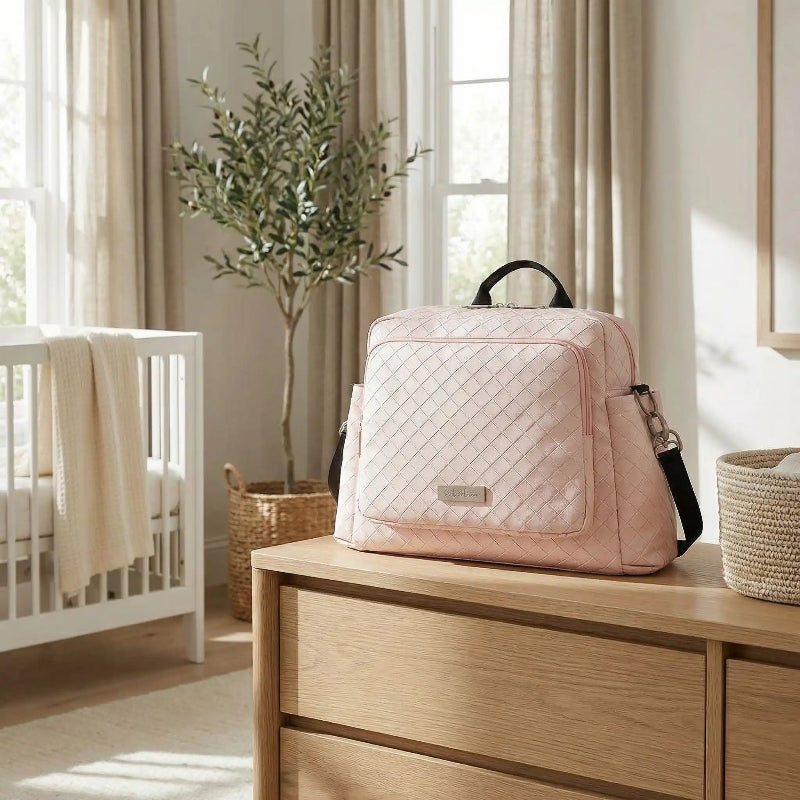 sac à langer rose sur mobilier de chambre