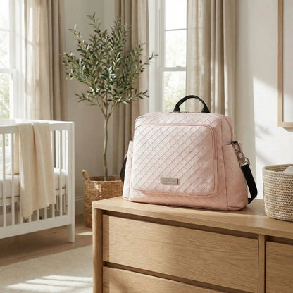 sac à langer rose sur mobilier de chambre